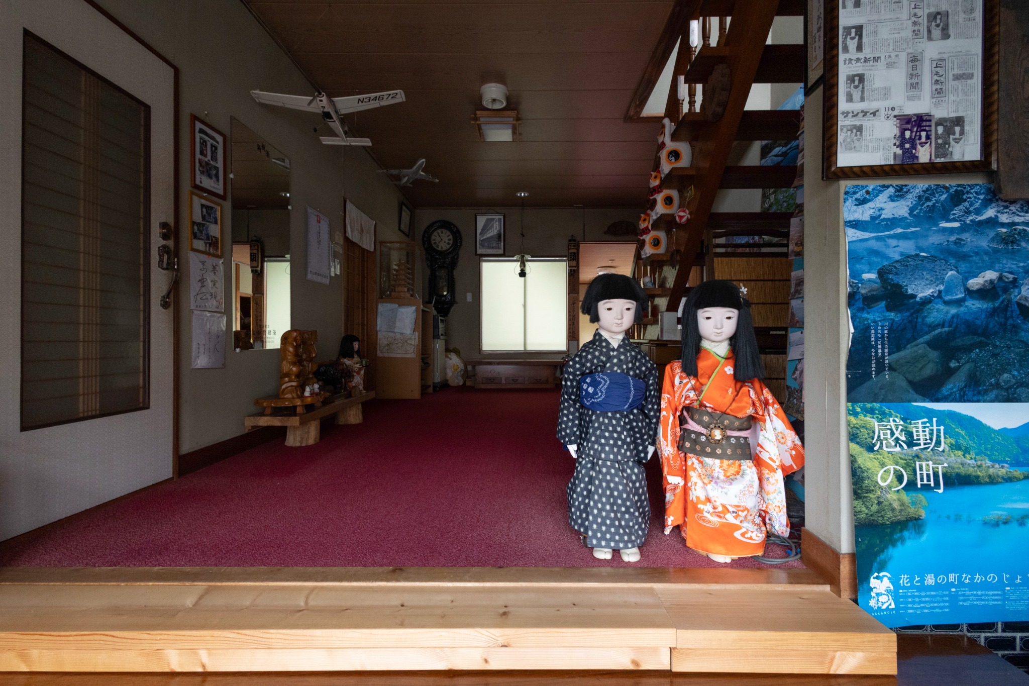古い階段や人形、展示物が見える旧旅館のエントランス