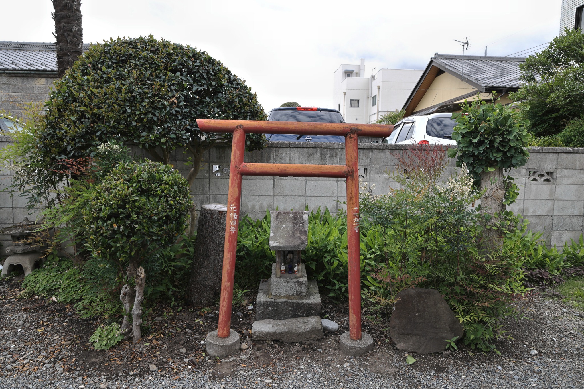 敷地内の庭にある小さな赤い鳥居と祠